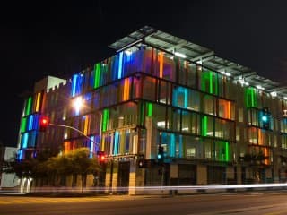 The exterior of a modern, glass-clad parking garage.